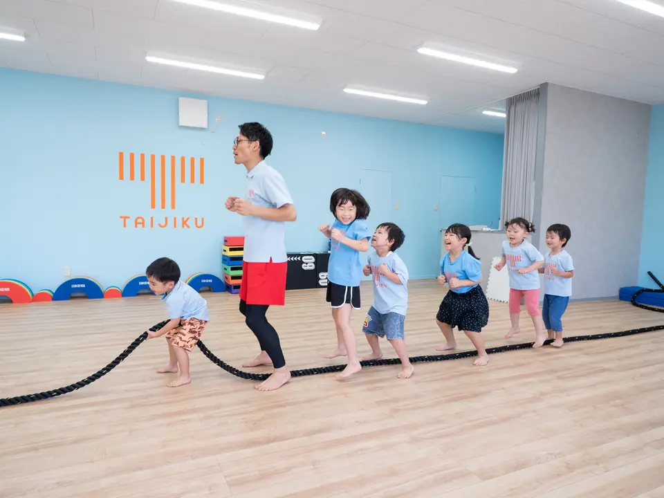 ロープを使って全身で遊ぶ子どもたちとスタッフ