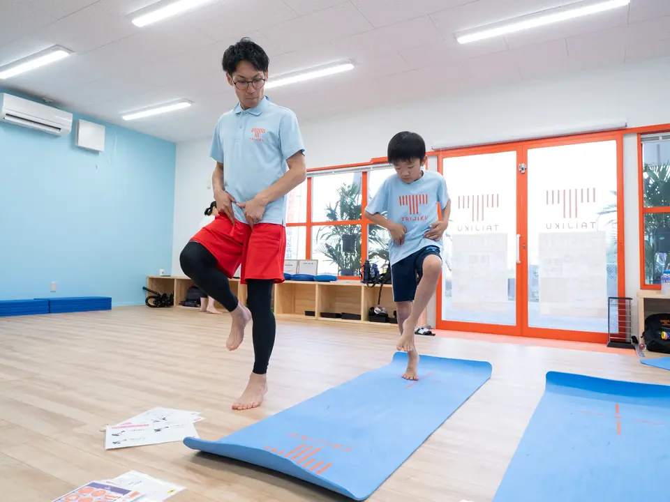 片脚で立ち、身体のバランスをコントロールする子ども
