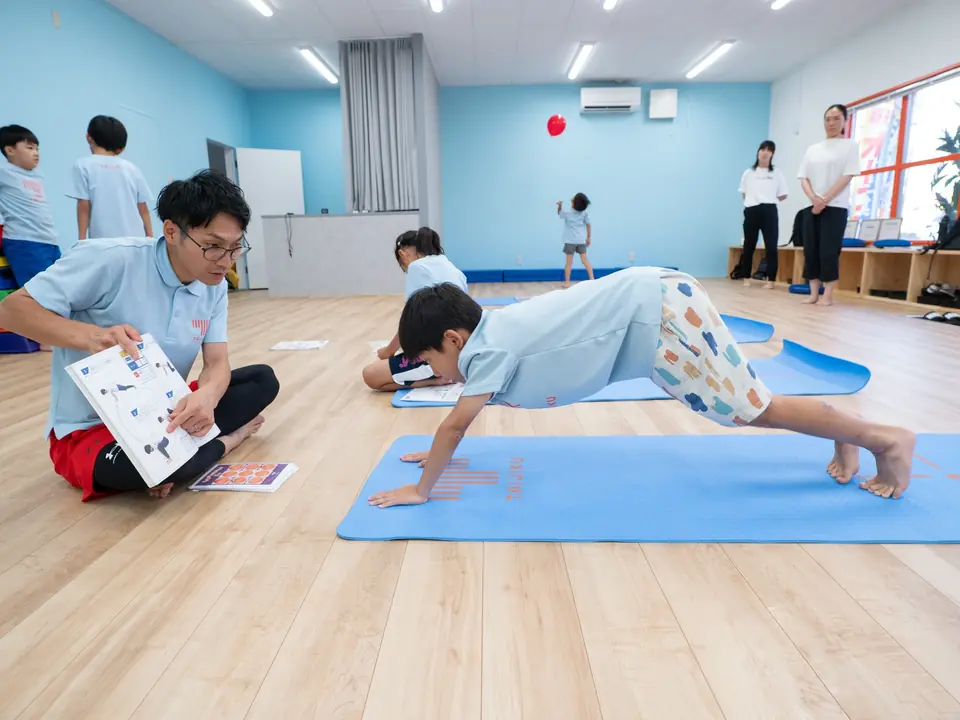 自分の身体を支えながら動き方を試している子ども