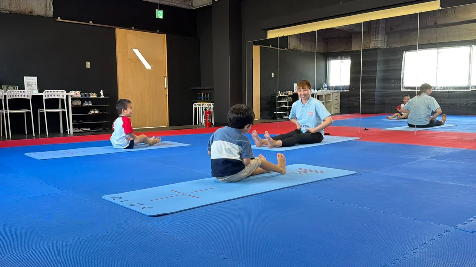 関内・桜木町校の通常レッスンで、トレーナーと子どもたちがマットの上で身体を動かしている様子