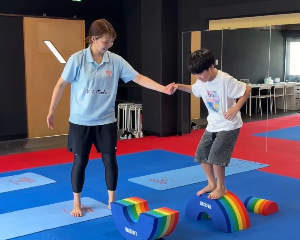通常レッスンで、トレーナーが手を添えながら子どもの挑戦を見守っている様子