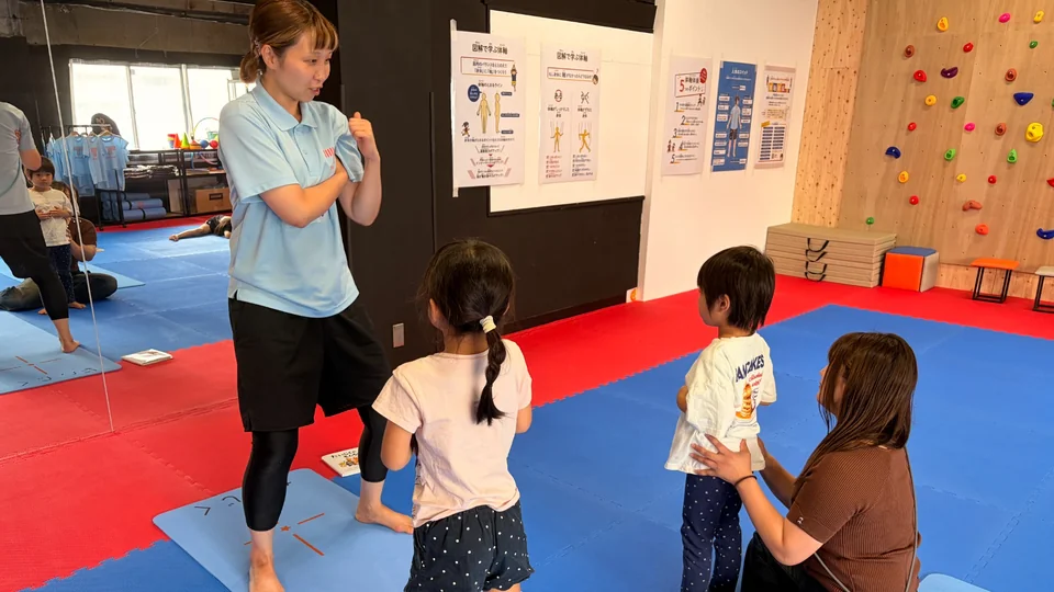 石井愛トレーナーが子どもたちに動きを見せながら指導している様子